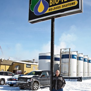 Man standing by outdoor sign in winter.