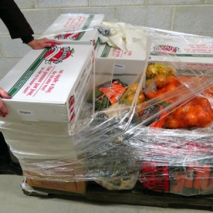 Wrapping a shipment of vegetables for delivery.