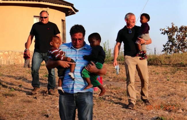 men carrying children in Africa