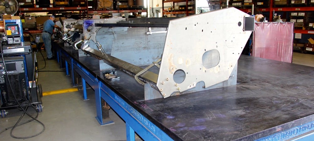 An employee uses one-off fabrication jigs in the R&D lab to assemble this prototype header for testing.