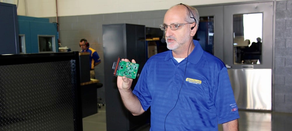 Terry Moyer, hay tools product validation manager, holds a circuit board sent to the R&D lab for testing. This year digital components play an increasingly important role in the brand’s haying equipment.