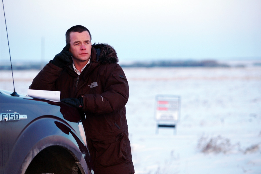 Man leaning on a pickup truck.
