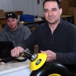 Man showing his mud-scraper farm invention.