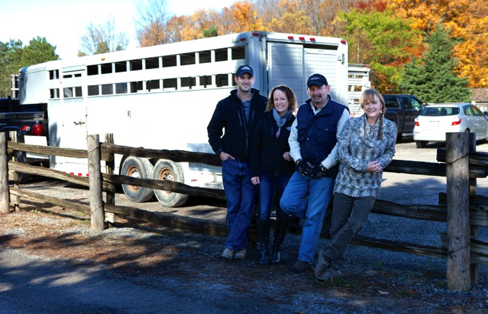 people standing beside livestock trailer