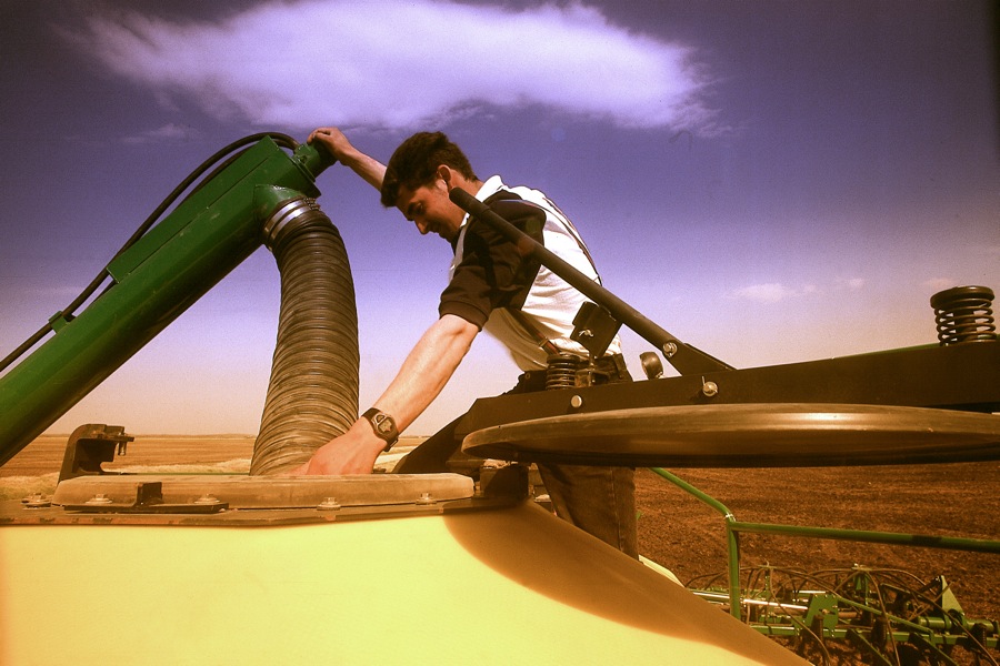 farmer loading grain with auger