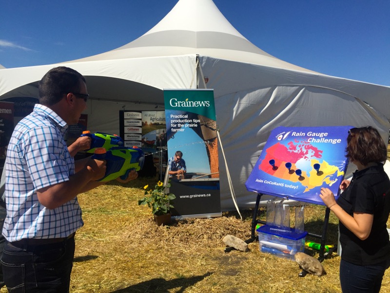 Saskatchewan farmers Henry and Aaron Van Ee take up the rain gauge challenge with water pistols at the CocoRaHs water gun booth.