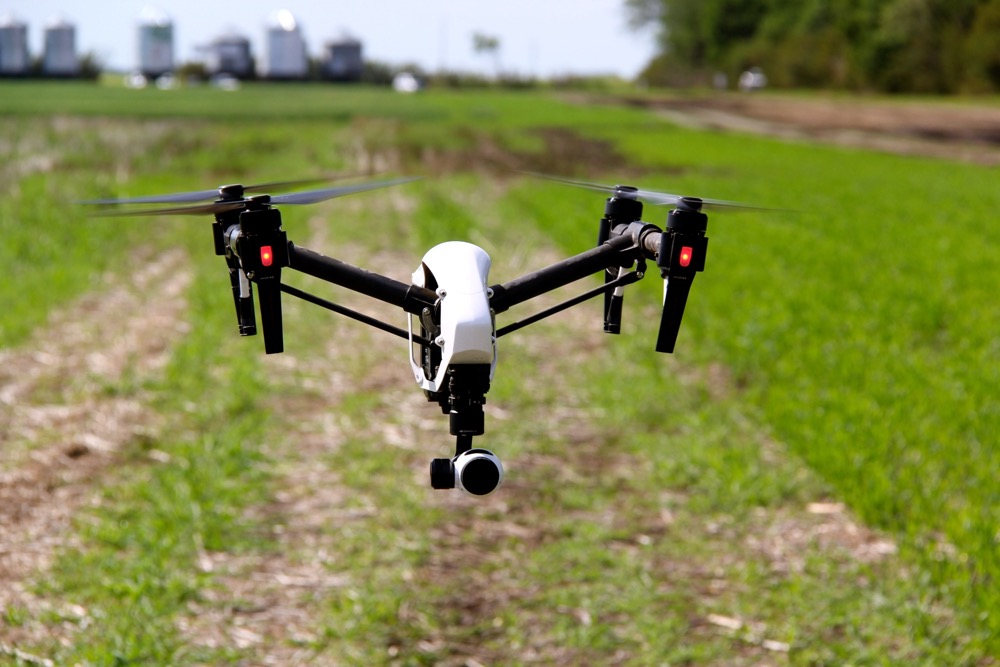 Scott Garvey, machinery editor for Grainews magazine, photographing a UAV (drone) at an in-field demo on the grounds of at Ag in Motion.