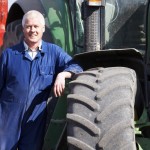 Driver Standing In Front Of Tractor