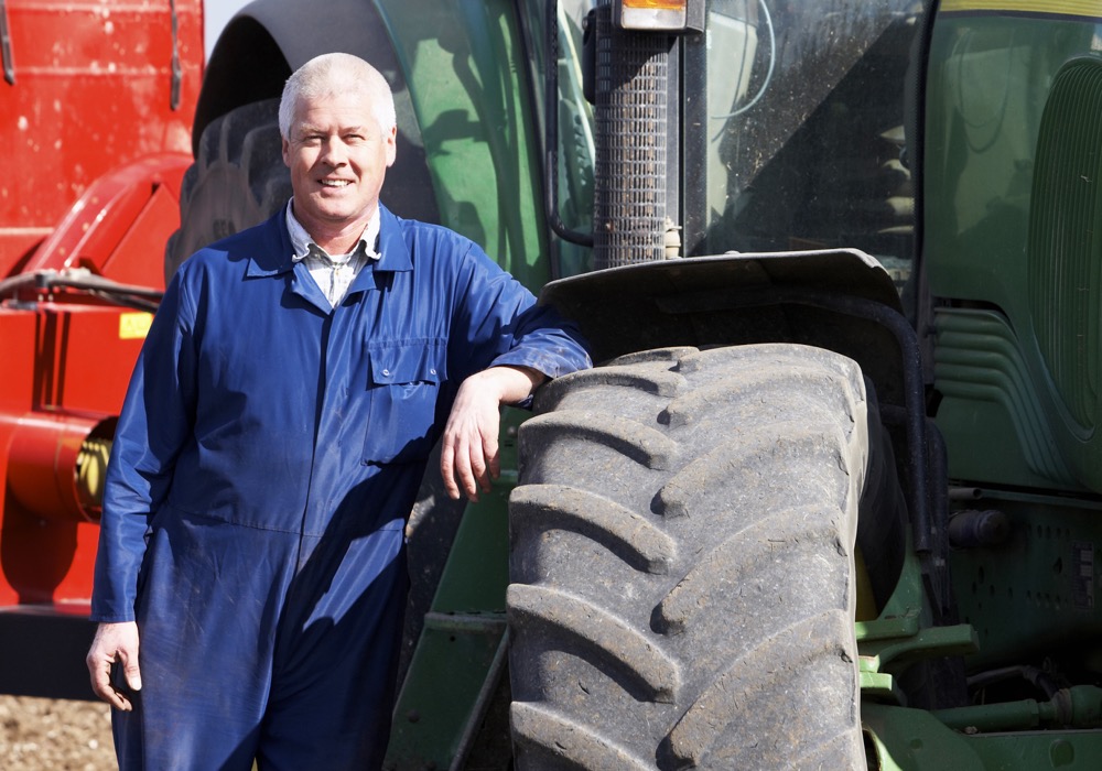 Driver Standing In Front Of Tractor