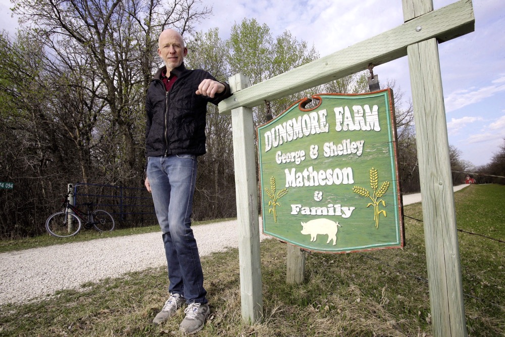 man beside farm sign