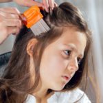 Mother using a comb to look for head lice. Selective focus