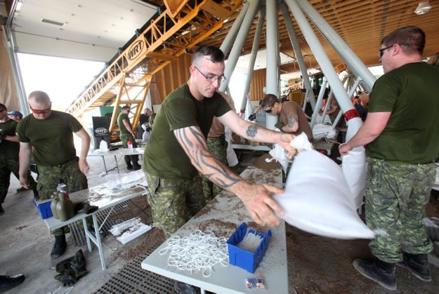 Soldiers prepare sandbags at Portage la Prairie, Man. to protect property at risk of flooding along the Assiniboine River. (Co-operator photo by Shannon VanRaes)
