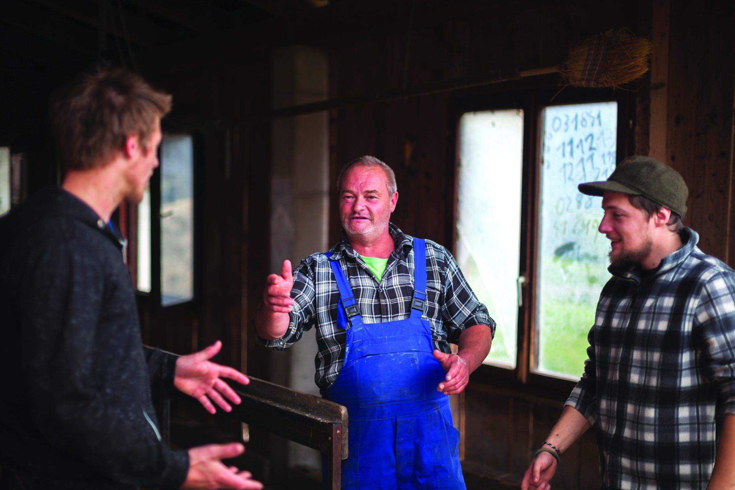 Farming Father Talking To His Sons in Agricultural Building.