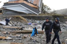RCMP officers near a building destroyed by Hurricane Fiona at Port aux Basques, N.L. on Sept. 26, 2022. (Photo: Reuters/John Morris)
