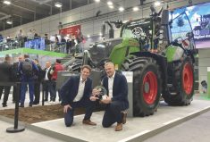 Fendt executives display their Tractor of the Year award in front of their winning model, the Fendt Gen7 728 Vario at the EIMA machinery show in Italy.