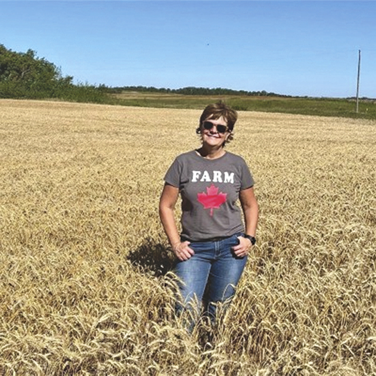 Alanna Koch standing in a wheat field