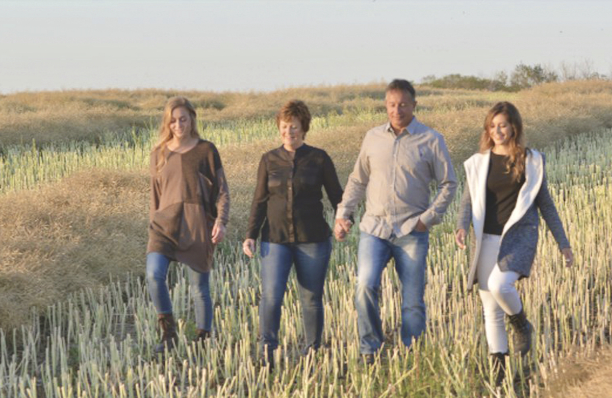 Alanna Koch and family in a field of canola stubble