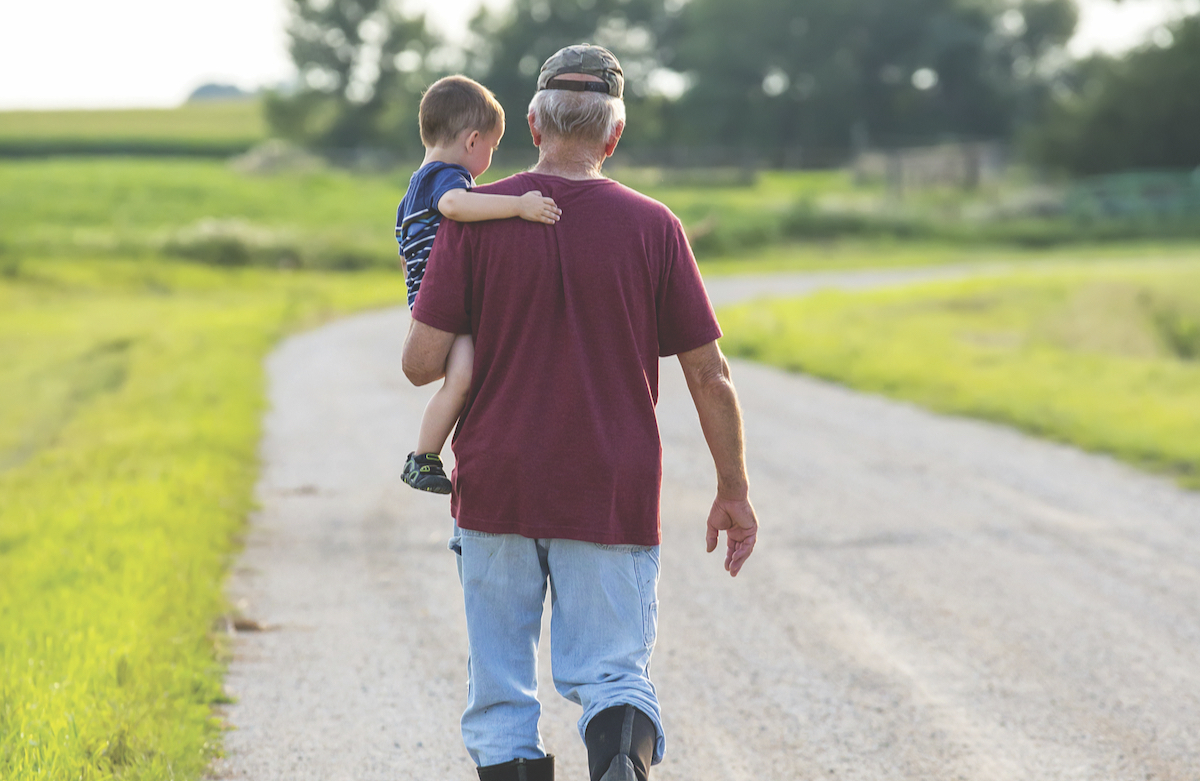 A grandfather carrying his grandson