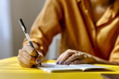 woman writing with a pen in a notebook