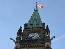 A Canadian flag flies at the top of one of the Parliament buildings in Ottawa. Photo: File
