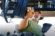 man inside the cab of a tractor working the controls