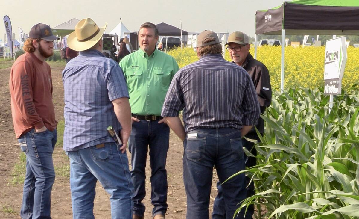 Spencer Harris , in the green shirt, speaks with attendees at the Nutrien Ag Solutions crop plots at Ag in Motion on July 16. Photo: Greg Berg