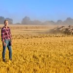 woman standing in a field of wheat stubble