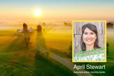 photo of April Stewart with a farm in the background at sunset