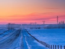 sunrise of prairie with power line in winter, alberta, canada.