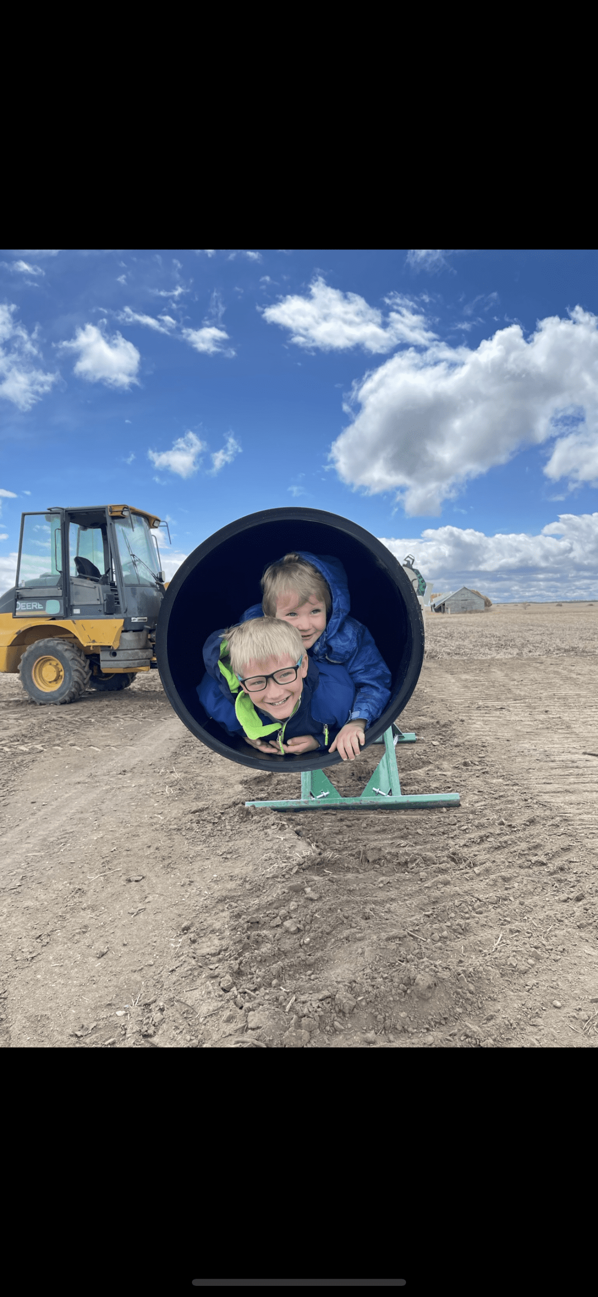 The size of the mainline pipe for the sub-surface irrigation. Two of Funk’s kids are inside to show the size. Credit: Brady Funk