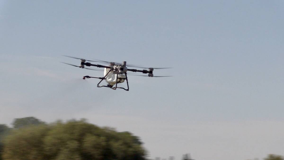 The DJI Agras T100 drone flies through the air during a demonstration at Canada&rsquo;s Outdoor Farm Show in Woodstock, Ont. Photo: Greg Berg
