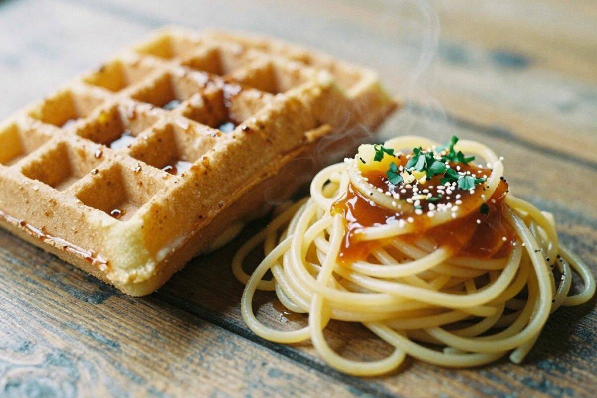 A ball of spaghetti and a waffle on a table.
